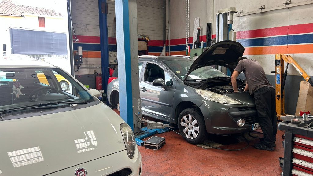 Mécanicien qui s'occupe d'une voiture Mécanicien qui s'occupe de la voiture d'un de nos clients